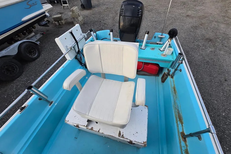 Slide: The Image of 1972 Boston Whaler 17 Montauk boat interior with white seating and blue deck. - 4
