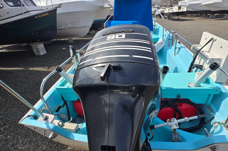 Slide: The Image of 1972 Boston Whaler 17 Montauk with 90 HP outboard motor, docked in a boatyard. - 6