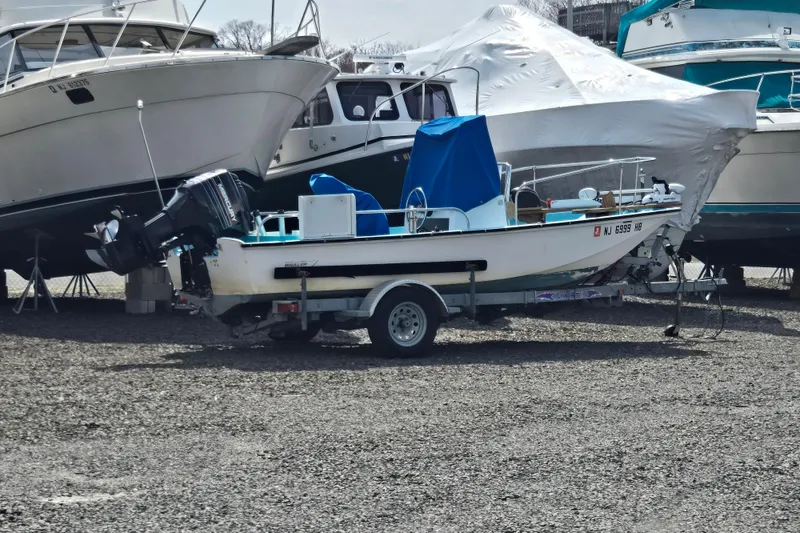 Slide: The Image of 1972 Boston Whaler 17 Montauk boat on trailer, parked among other boats. - 8