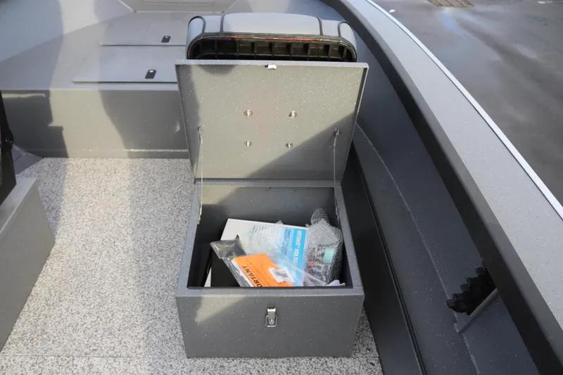 Slide: The Image of Open storage compartment in 2026 Alumaweld Adventurer 18 boat, containing various items. - 6