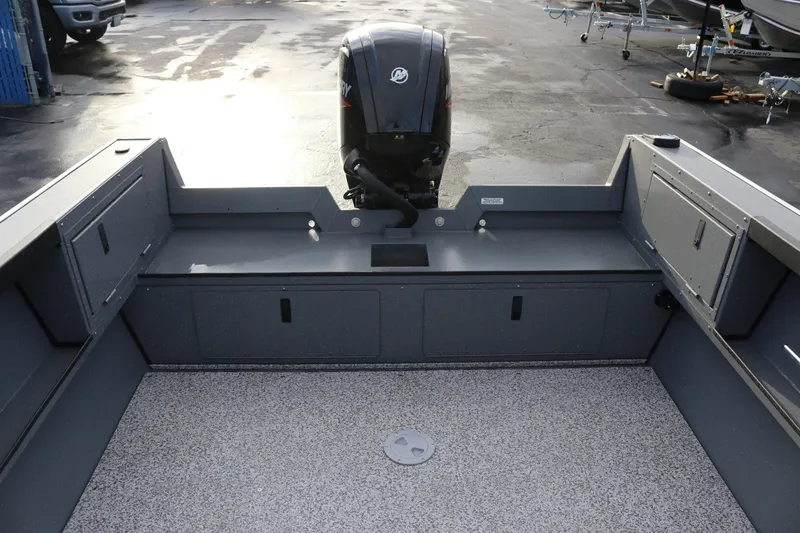 Slide: The Image of 2026 Alumaweld Adventurer 18 boat interior with motor, featuring spacious deck and storage compartments. - 7