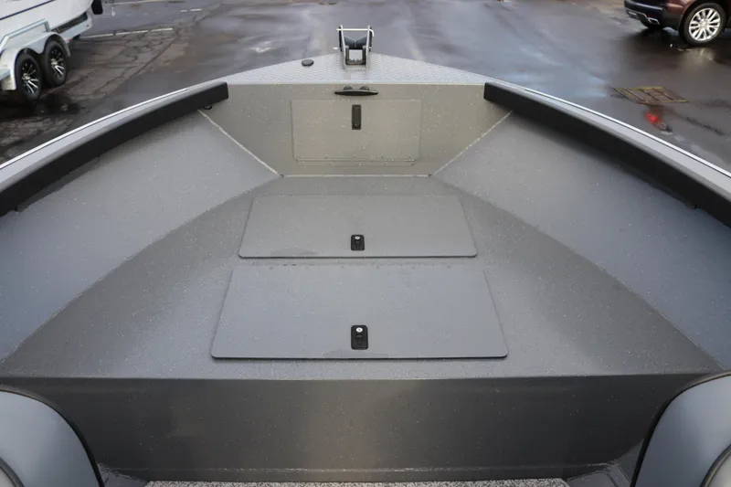 Slide: The Image of 2026 Alumaweld Adventurer 18 boat interior with storage compartments on a wet dock. - 8