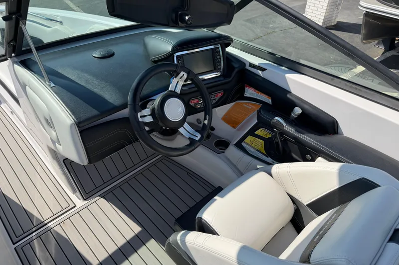 Slide: The Image of Interior of 2015 Nautique Super Air Nautique 230 boat, featuring sleek dashboard and steering wheel. - 10