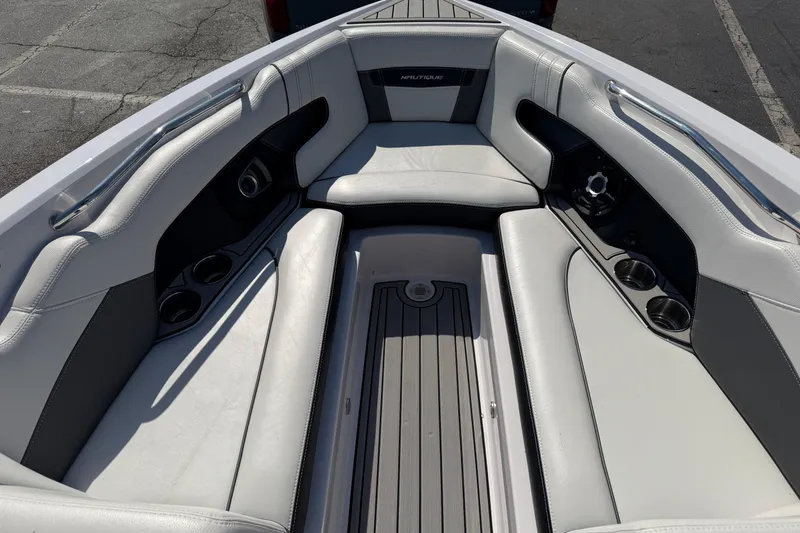 Slide: The Image of Interior of 2015 Nautique Super Air Nautique 230 boat with cushioned seating and cup holders. - 11