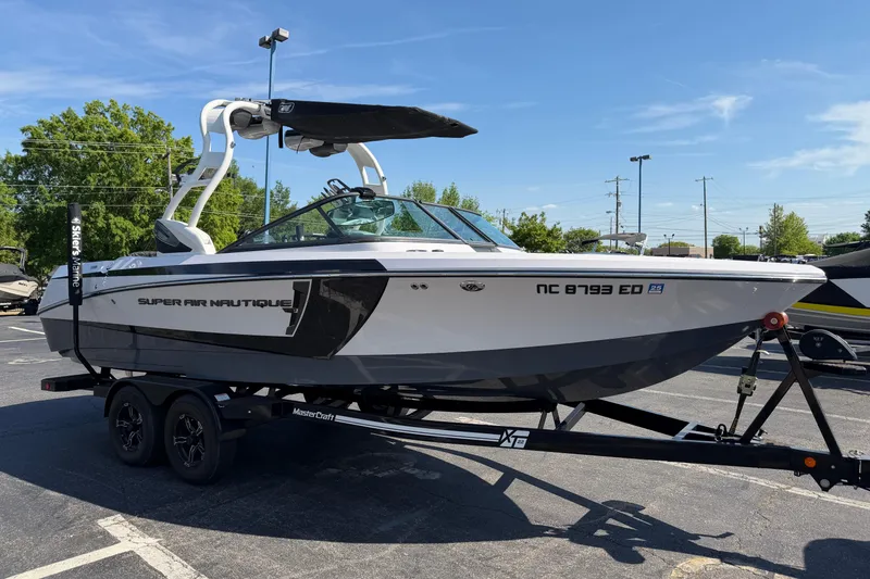 Slide: The Image of 2015 Nautique Super Air Nautique 230 boat on trailer in parking lot. - 4
