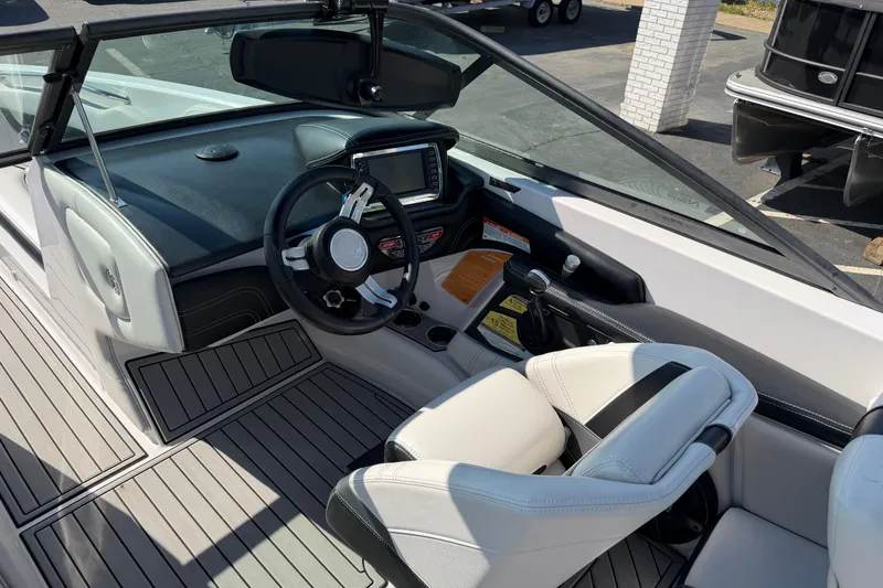 Slide: The Image of 2015 Nautique Super Air Nautique 230 boat interior with steering wheel and dashboard controls. - 7