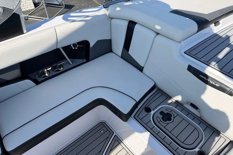 Slide: The Image of Interior seating of a 2015 Nautique Super Air Nautique 230 boat, featuring sleek design and cup holders. - 9