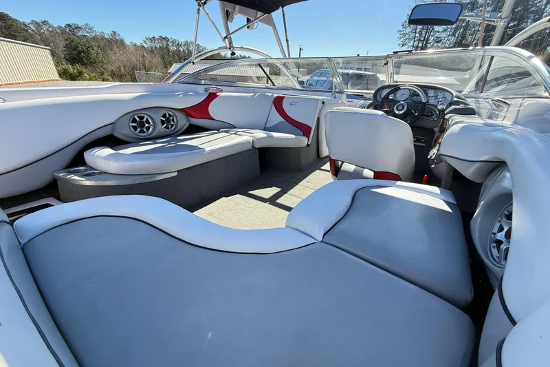 Slide: The Image of 2004 Nautique Air Nautique 226 boat interior with white and red seating, dashboard, and speakers. - 11