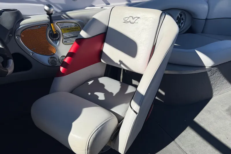 Slide: The Image of 2004 Nautique Air Nautique 226 boat interior with steering wheel and cushioned seat. - 13