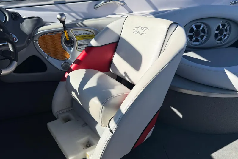 Slide: The Image of 2004 Nautique Air Nautique 226 interior with steering wheel, control panel, and cushioned seating. - 14