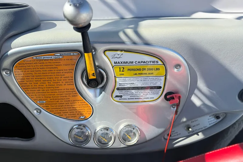 Slide: The Image of 2004 Nautique Air Nautique 226 dashboard with capacity warning and control lever. - 16