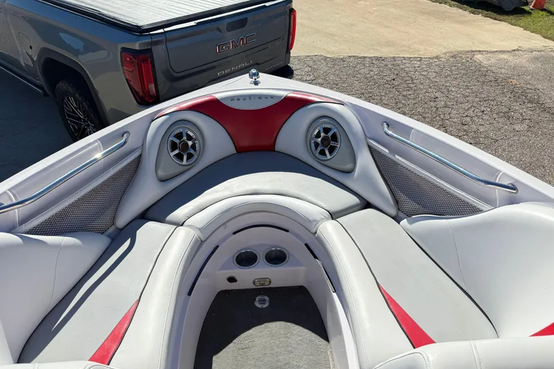 Slide: The Image of 2004 Nautique Air Nautique 226 boat interior with red and gray seating, near GMC Denali. - 17