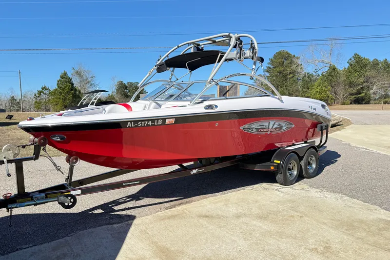 Slide: The Image of 2004 Nautique Air Nautique 226 boat on trailer, red and white, parked outdoors. - 3
