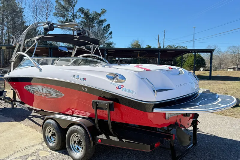 Slide: The Image of 2004 Nautique Air Nautique 226 boat on trailer, red and white design, parked outdoors. - 5