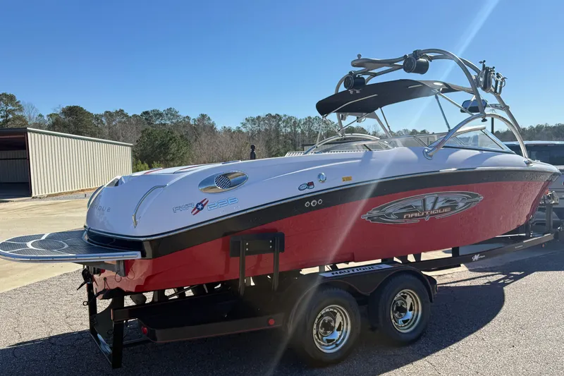 Slide: The Image of 2004 Nautique Air Nautique 226 boat on trailer, red and white design, parked outdoors. - 7