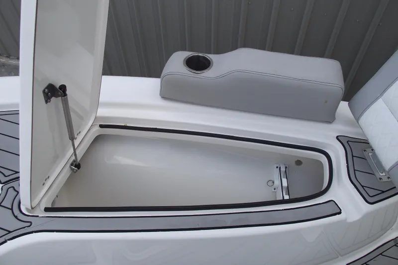 Slide: The Image of 2019 Sea Pro 208 Bay boat storage compartment with cushioned seating and cup holder. - 12
