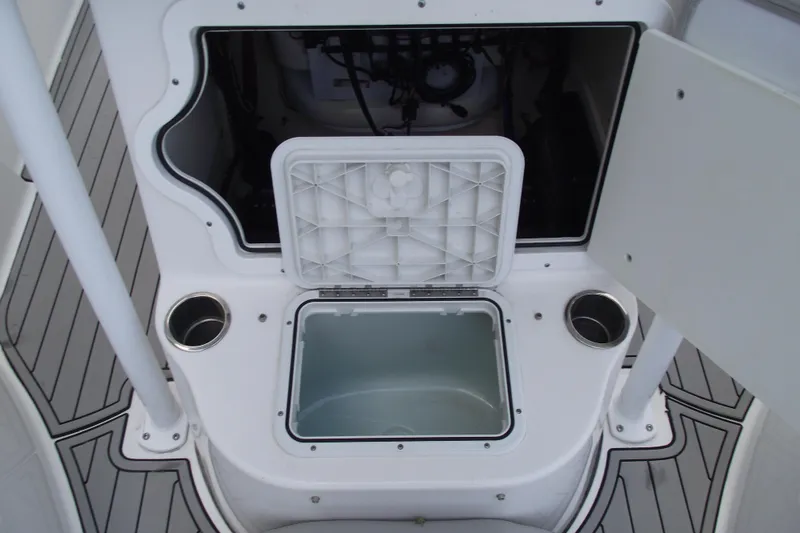 Slide: The Image of 2019 Sea Pro 208 Bay boat storage compartment with open hatch and cup holders. - 16