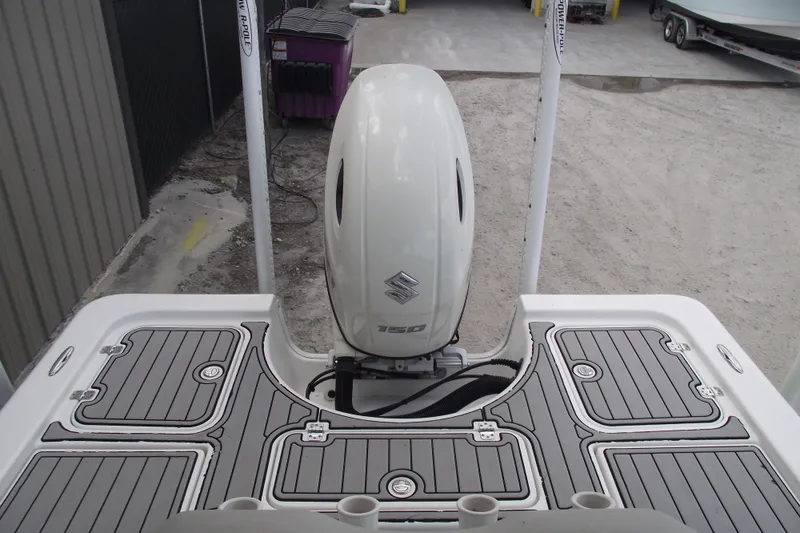 Slide: The Image of 2019 Sea Pro 208 Bay boat with Suzuki 150 outboard motor, docked on a textured surface. - 27