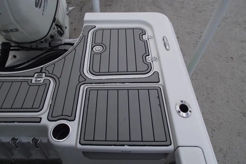 Slide: The Image of 2019 Sea Pro 208 Bay boat deck with gray non-slip surface and storage compartments. - 28