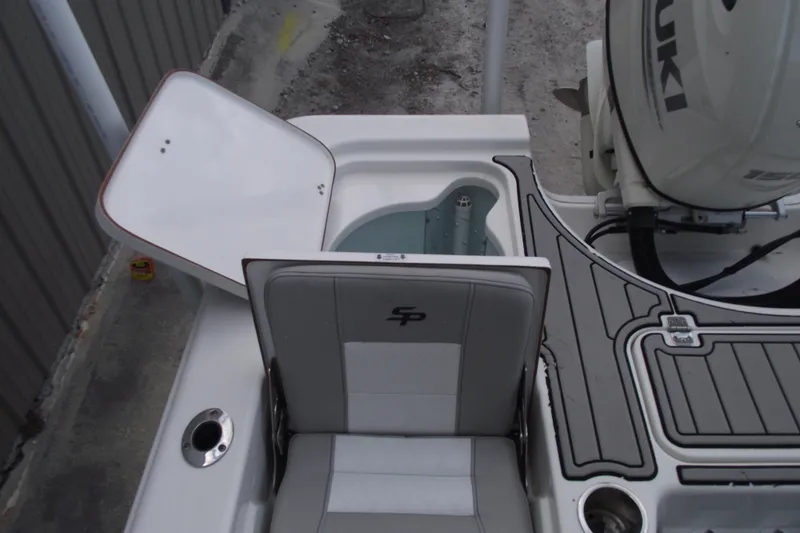 Slide: The Image of 2019 Sea Pro 208 Bay boat interior with open storage compartment and Suzuki engine. - 34
