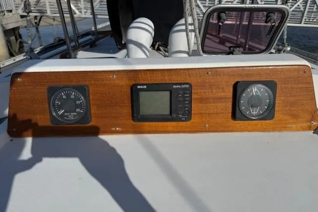 Slide: The Image of Electrical panel inside 1983 Tayana 55 yacht, featuring wooden interior and red control board. - 13