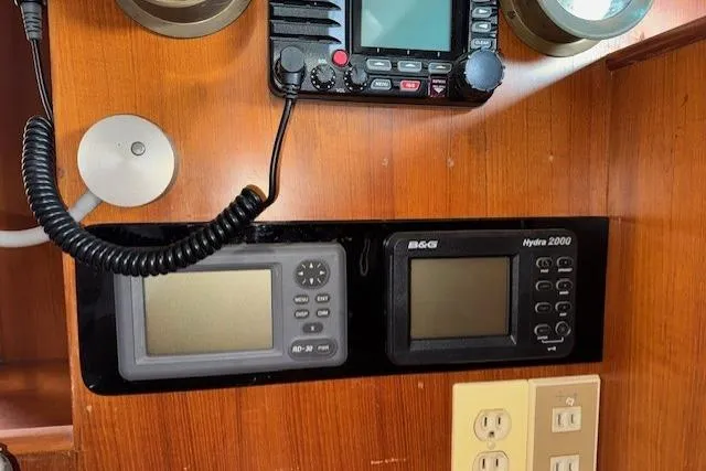 Slide: The Image of Navigation station in 1983 Tayana 55 yacht with wooden interior and control panel. - 16