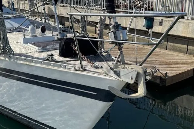 Slide: The Image of 1983 Tayana 55 sailboat docked in a marina, surrounded by calm waters and other boats. - 2