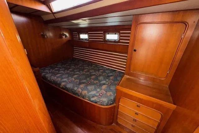 Slide: The Image of Bathroom interior of 1983 Tayana 55 yacht with blue cabinetry and white countertop. - 24