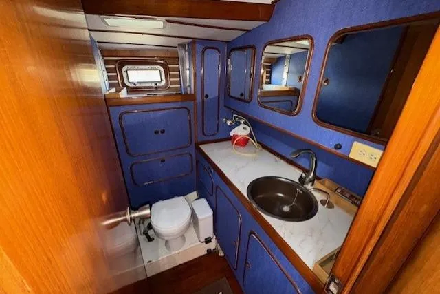 Slide: The Image of Cozy wooden interior of 1983 Tayana 55 yacht cabin with bed and storage. - 25