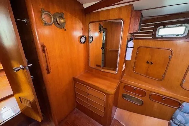 Slide: The Image of Interior of 1983 Tayana 55 yacht with wooden paneling and cozy cabin space. - 27
