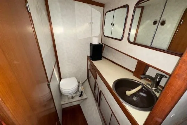 Slide: The Image of Compact bathroom in 1983 Tayana 55 yacht with sink, mirror, and wooden accents. - 29
