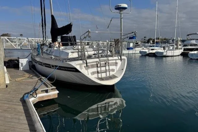 Slide: The Image of 1983 Tayana 55 sailboat docked at marina, featuring spacious deck and rigging. - 3