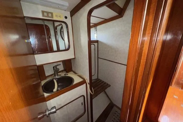 Slide: The Image of Engine room of 1983 Tayana 55 sailboat, featuring mechanical components and wiring. - 30