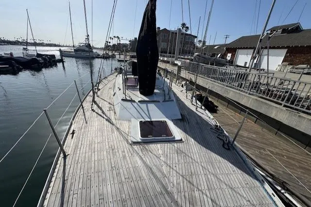 Slide: The Image of Tayana 55 sailboat from 1983 docked at a marina, featuring a spacious deck. - 5