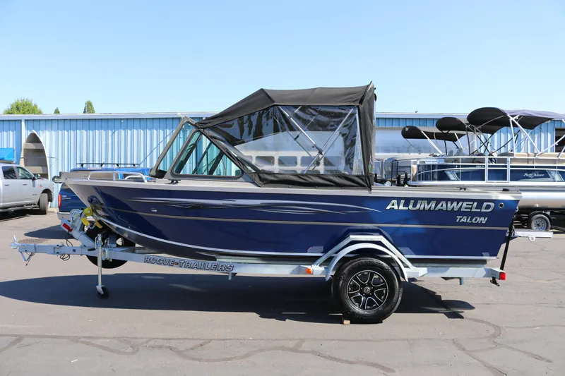 Slide: The Image of 2026 Alumaweld Talon 18 boat on trailer, blue exterior, parked outdoors. - 24