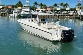 Slide: The Image of 2001 Intrepid 377 Walkaround boat docked in a marina with palm trees. - 1