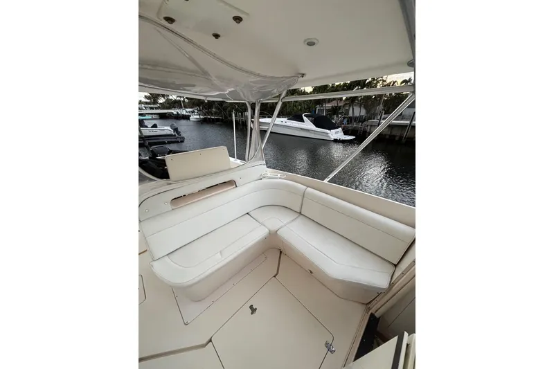 Slide: The Image of 2001 Intrepid 377 Walkaround boat interior with white seating, docked by the water. - 16