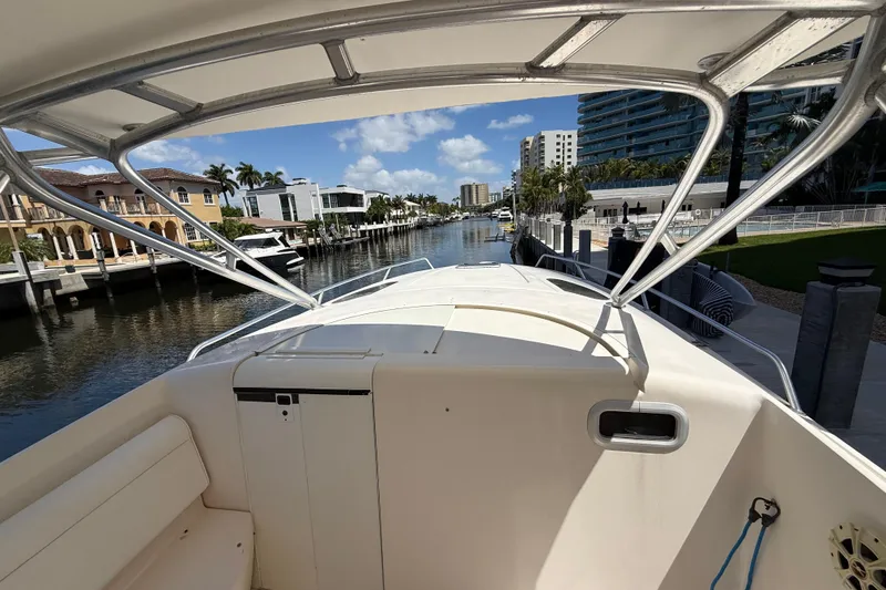 Slide: The Image of 2001 Intrepid 377 Walkaround boat docked in a scenic waterfront area. - 18