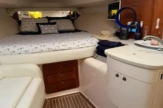 Slide: The Image of 2001 Intrepid 377 Walkaround cabin interior with bed, seating, and compact kitchenette. - 23
