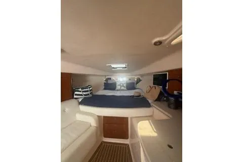 Slide: The Image of 2001 Intrepid 377 Walkaround cabin interior with bed, seating, and nautical decor. - 24