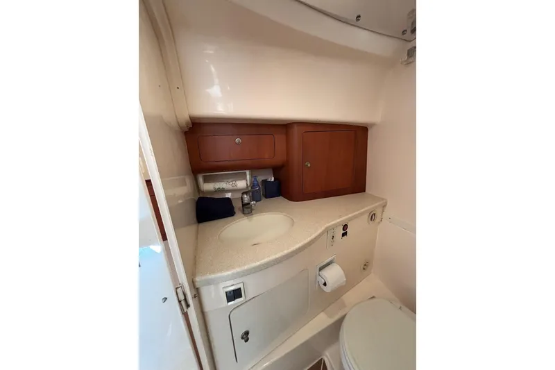 Slide: The Image of 2001 Intrepid 377 Walkaround boat bathroom with sink, wooden cabinets, and toilet. - 30