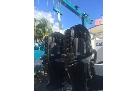 Slide: The Image of 2001 Intrepid 377 Walkaround boat engines under a blue crane with palm trees in the background. - 38