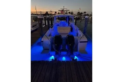 Slide: The Image of 2001 Intrepid 377 Walkaround boat docked with blue underwater lights at sunset. - 42