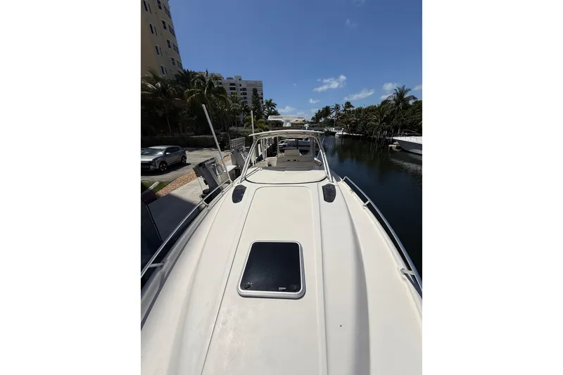 Slide: The Image of 2001 Intrepid 377 Walkaround boat docked by a canal under a clear blue sky. - 44