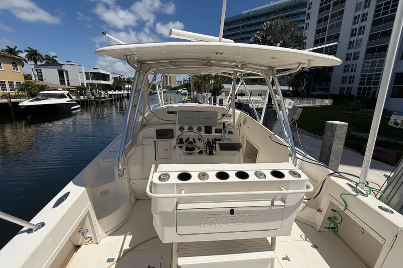 Slide: The Image of 2001 Intrepid 377 Walkaround boat docked near waterfront homes and buildings. - 7