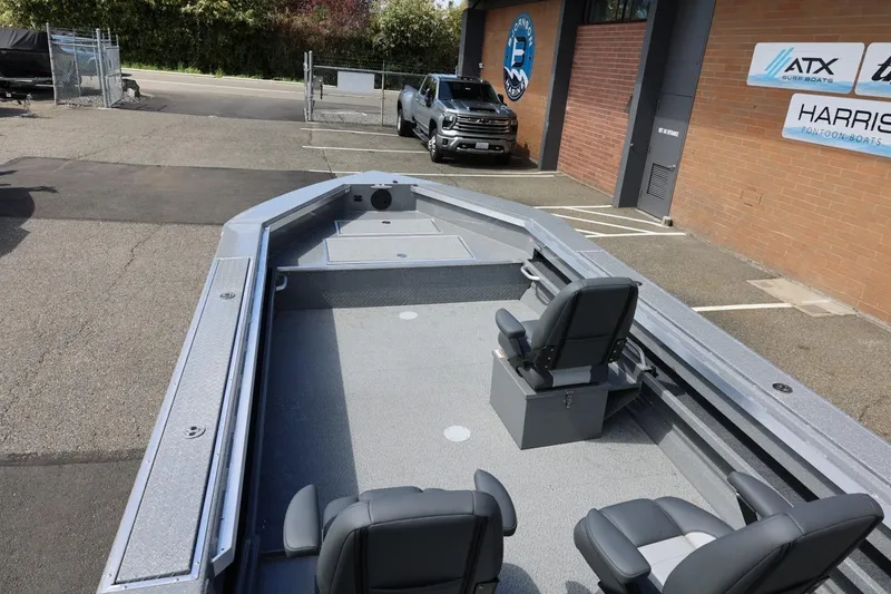 Slide: The Image of 2026 Thunder Jet 209 Rush OT boat interior with seating, parked outside dealership. - 16