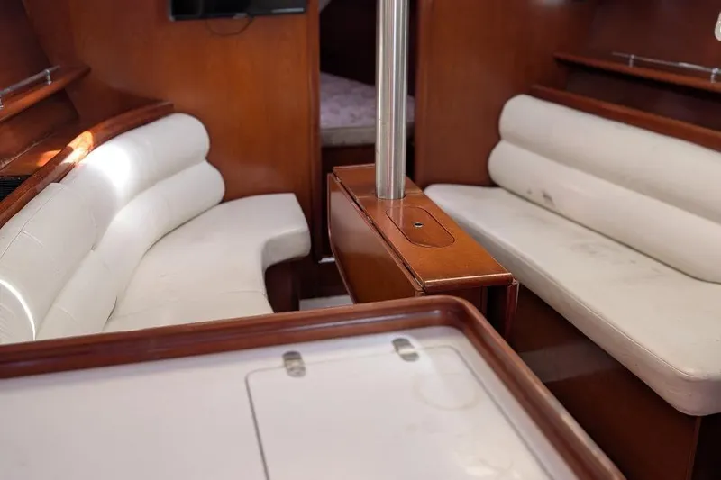 Slide: The Image of Interior of 2006 Beneteau 343 sailboat with white seating and wooden accents. - 10
