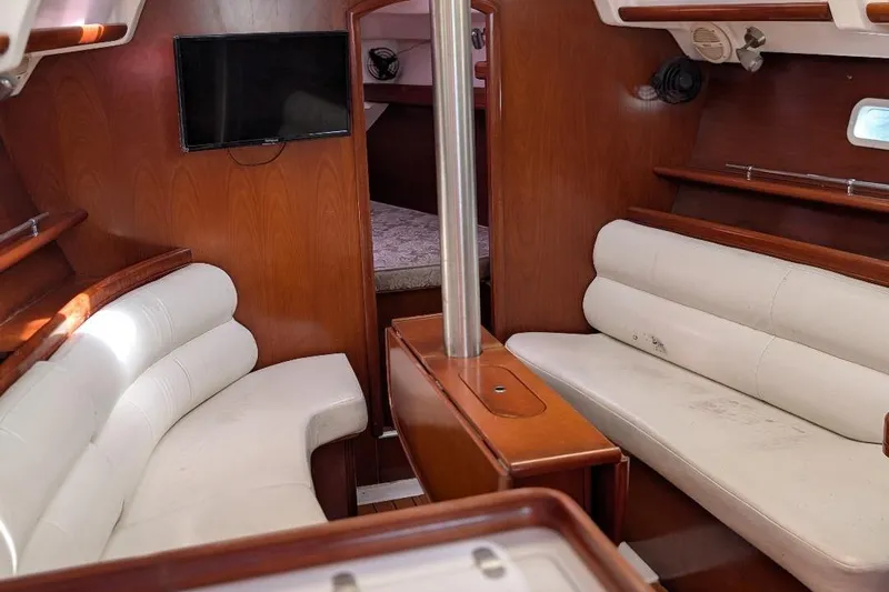 Slide: The Image of Interior of 2006 Beneteau 343 sailboat with white seating and wood finish. - 9