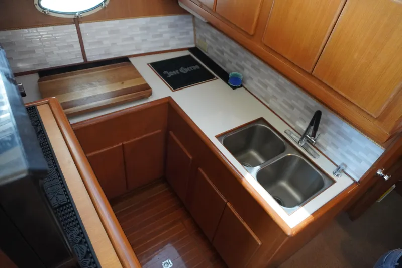Slide: The Image of 1996 Symbol 41 Aft Cabin Yacht kitchen with double sink and wooden cabinets. - 29