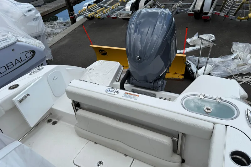 Slide: The Image of 2022 Edgewater 230CC boat with outboard motor, docked near trailers and equipment. - 11